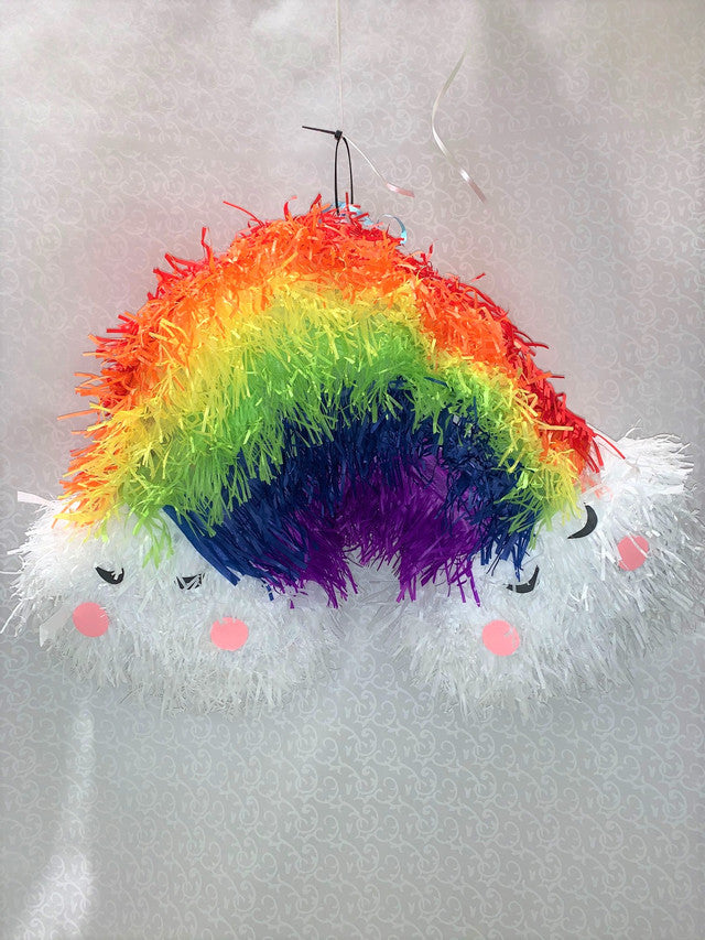 Piñata en forme d'arc-en-ciel coloré avec deux petit nuage au bas de celui-ci